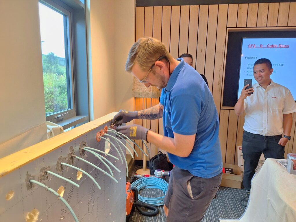 Colleague Chris practices firestopping technique in front of the class.